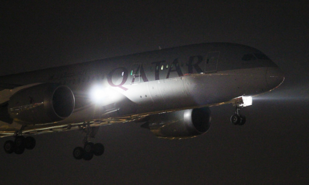Lądowanie Dreamlinera Katarskich Linii Lotniczych Qatar Airways nocą.